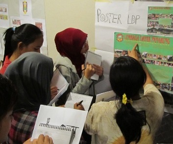 Young women looking at posters and taking notes